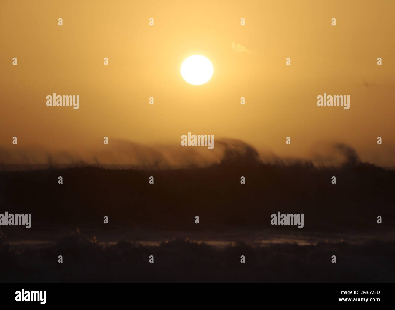Montecito, California, U.S.A. 6th Jan, 2023. A yellow sunset over spectacular dark waves at Butterfly Beach, in front of the Four Season's Hotel in Montecito, California, near Santa Barbara, after a frightening storm caused evacuations. (Credit Image: © Amy Katz/ZUMA Press Wire) Stock Photo