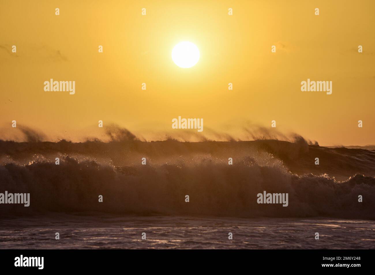 Montecito, California, U.S.A. 6th Jan, 2023. A yellow sunset over spectacular dark waves at Butterfly Beach, in front of the Four Season's Hotel in Montecito, California, near Santa Barbara, after a frightening storm caused evacuations. (Credit Image: © Amy Katz/ZUMA Press Wire) Stock Photo