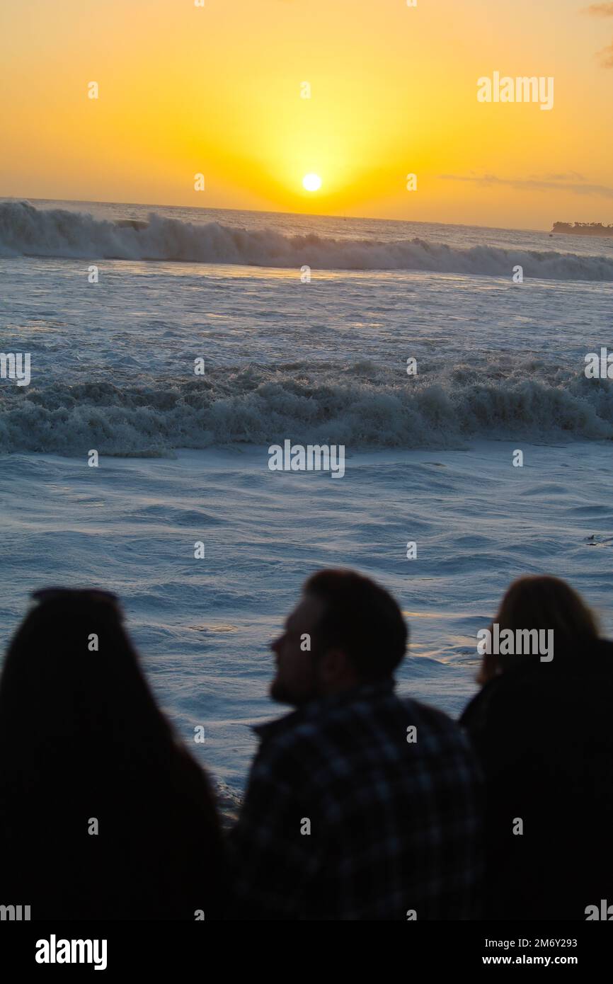 Montecito, California, U.S.A. 6th Jan, 2023. Santa Barbara Country residents flock to Butterfly Beach, in front of the Four Season's Hotel ''” a popular beach where the royals and celebrities are often spotted ''” to see the giant waves brought on by the storm surge and atmospheric river after days of rain ''” a rare occurrence. Much of Montecito was evacuated the previous night due to concerns of mud and landslides. This week marks the five year anniversary of the Montecito Mudslides that followed the Thomas Fire and killed 23 people, so many were on edge, but during this dryer, sunset ho Stock Photo