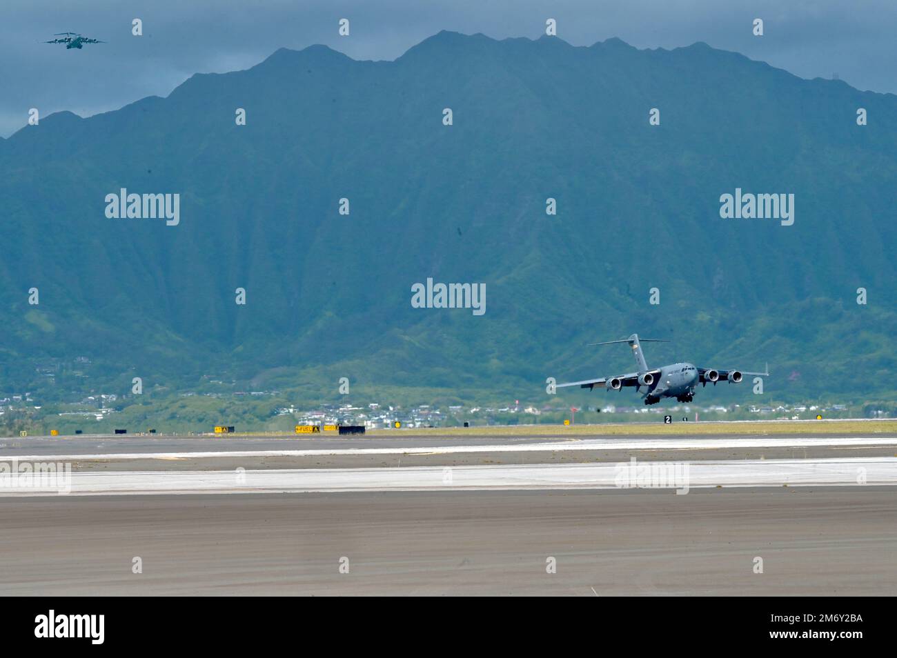 Two U.S. Air Force C-17 Globemaster IIIs come in for a landing during Exercise Global Dexterity 2022 at Marine Corps Base Hawaii, Hawaii, May 11, 2022. The 15th Wing, Hawaii Air National Guard, and Royal Australian Air Force conducted “full stop” training at MCBH as the first part of a day of training around the Hawaiian islands during Exercise Global Dexterity 20222. Stock Photo