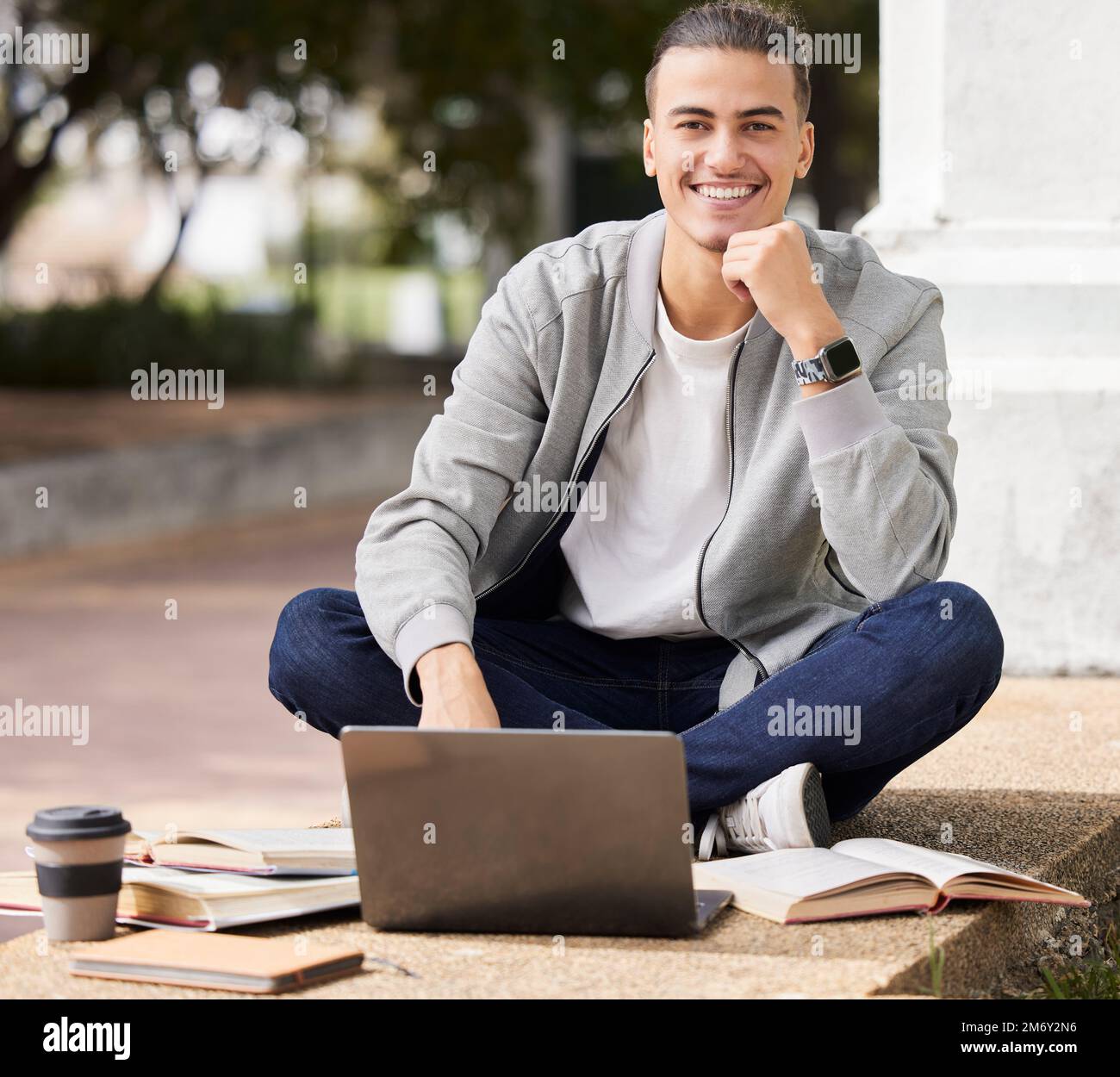 Education, laptop and student studying at college, online learning and exam preparation in Canada. School, scholarship and portrait of a man reading Stock Photo