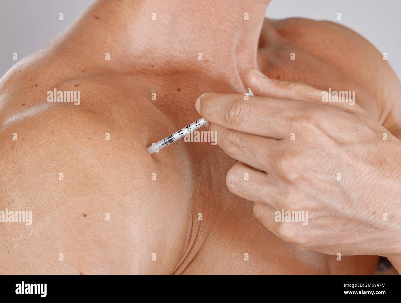 Closeup, man and botox injection, skincare and cosmetics with grey studio background. Male, guy and needle for serum, beauty and plastic surgery for Stock Photo