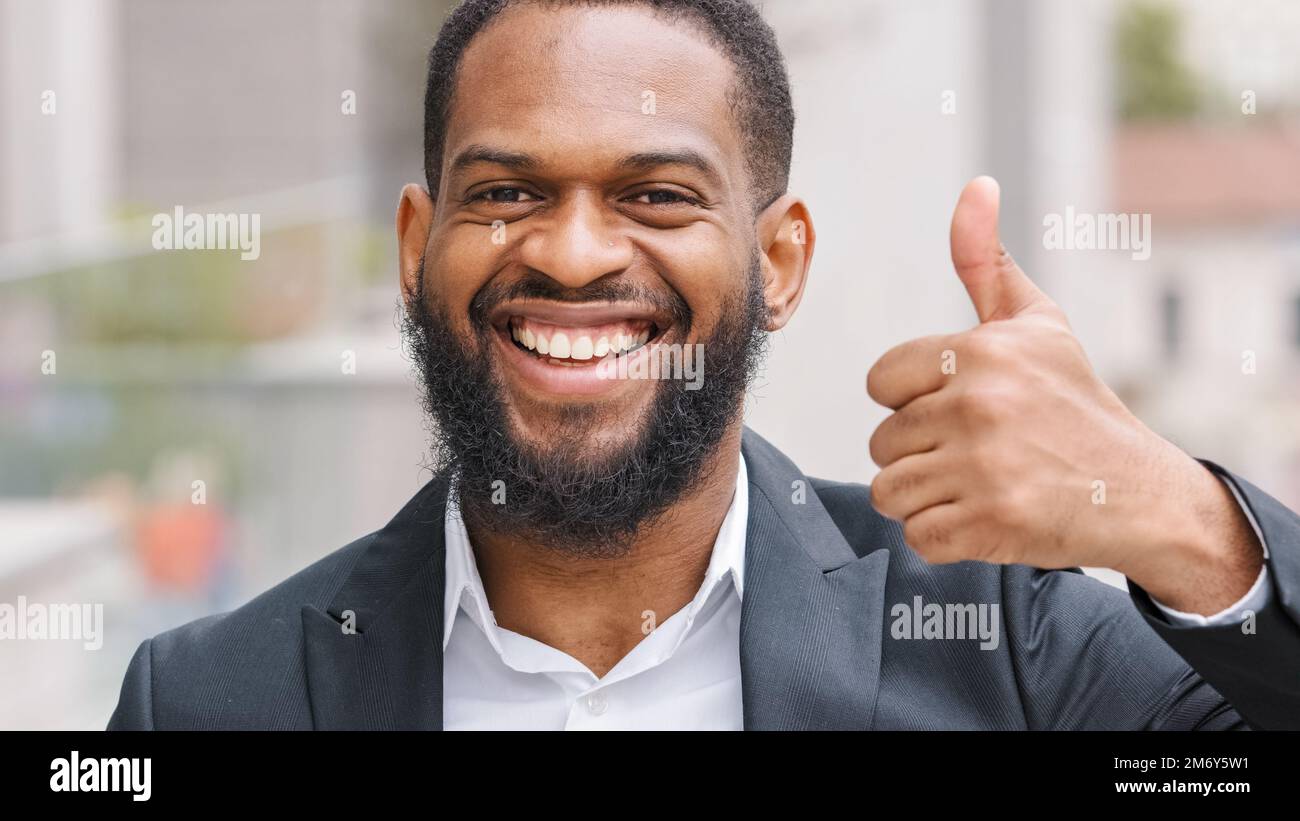 Millennial bearded happy smiling ethnic African American male businessman boss man entrepreneur employer showing thumb up demonstrate satisfaction Stock Photo