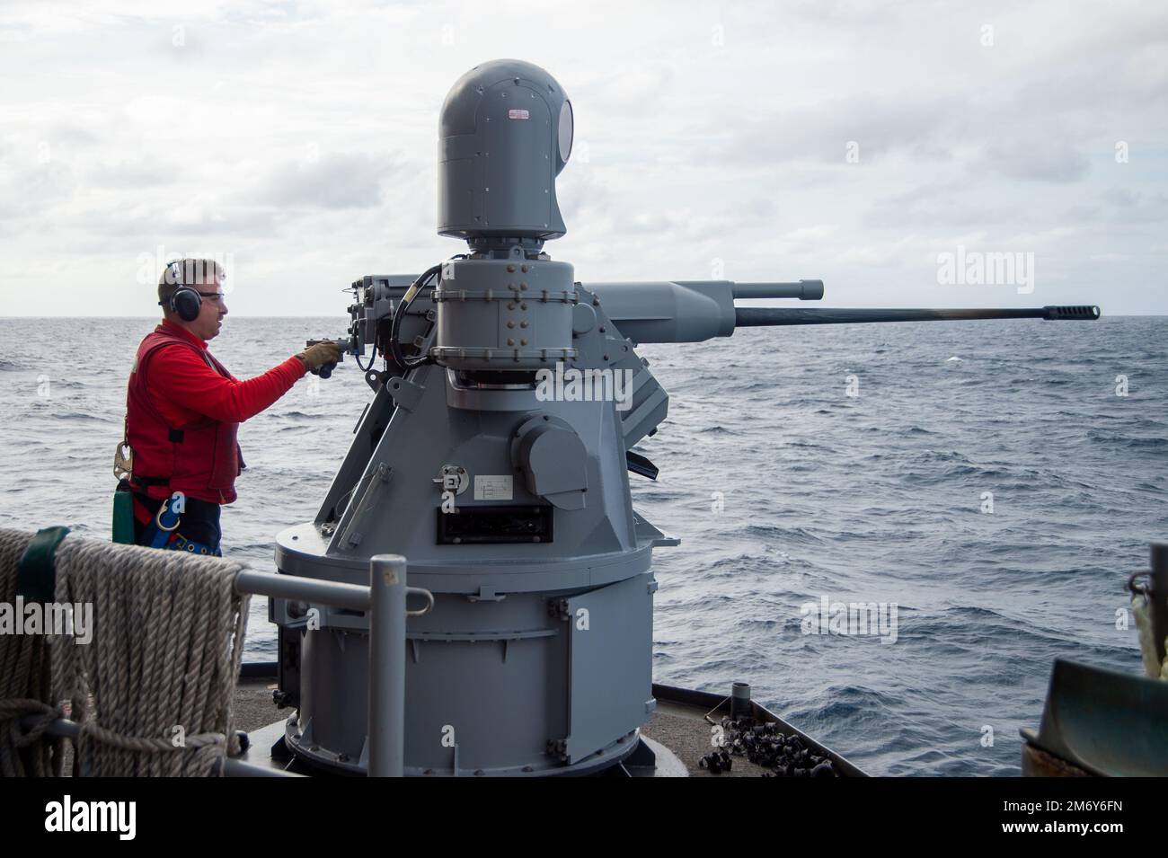 20510-N-YX844-2148 PACIFIC OCEAN (May 10, 2022) Gunner’s Mate 2nd Class Ian Johnson, from Louisville, Kentucky, manually fires a MK 38 Machine Gun System on the fantail of the U.S. Navy’s only forward-deployed aircraft carrier USS Ronald Reagan (CVN 76), during a live fire exercise. The MK 38 is a remote controlled weapon system that fires 25 mm rounds. Ronald Reagan, the flagship of Carrier Strike Group 5, provides a combat-ready force that protects and defends the United States, and supports alliances, partnerships and collective maritime interests in the Indo-Pacific region. Stock Photo