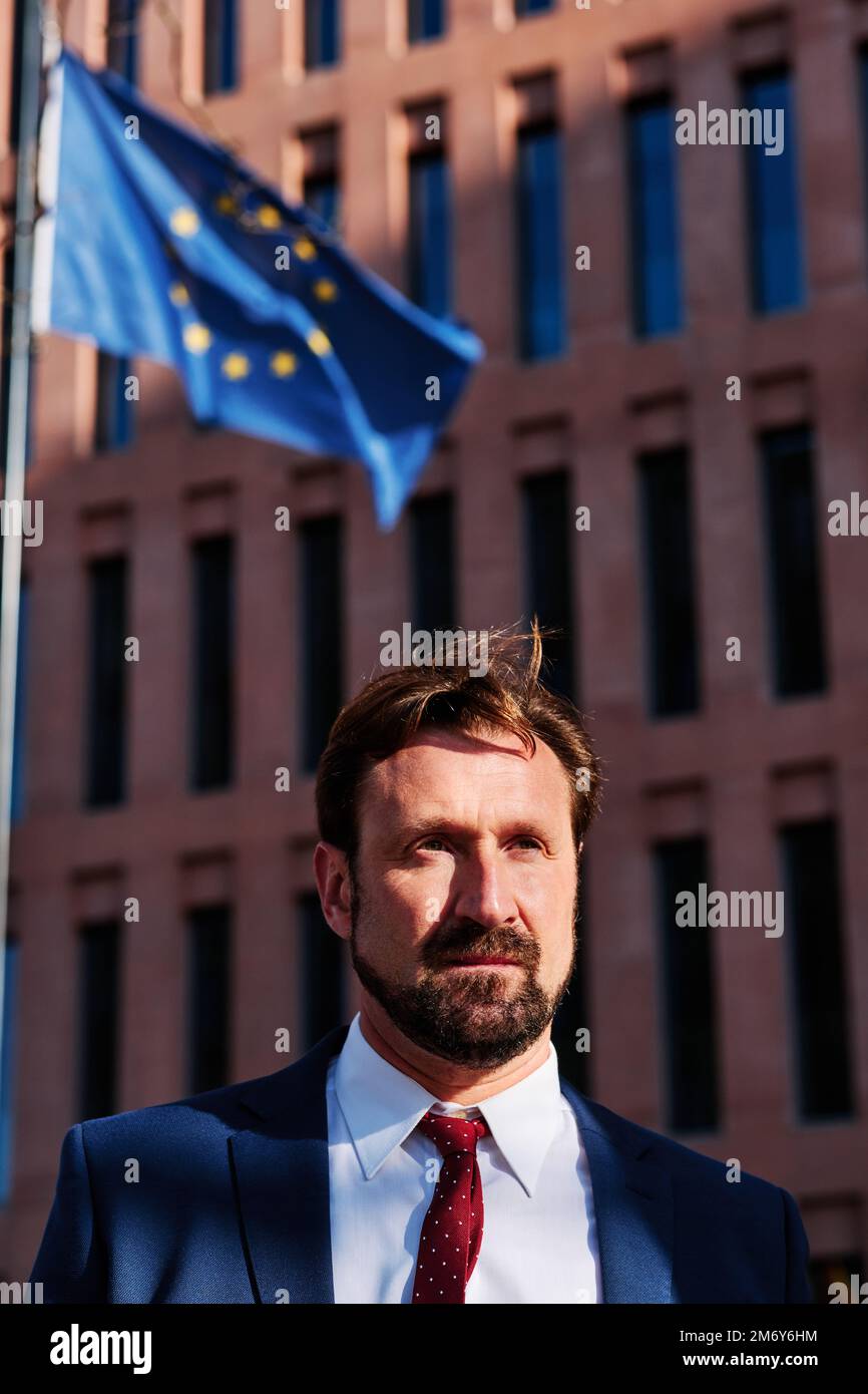 Businessman in front of a building with the European flag Stock Photo