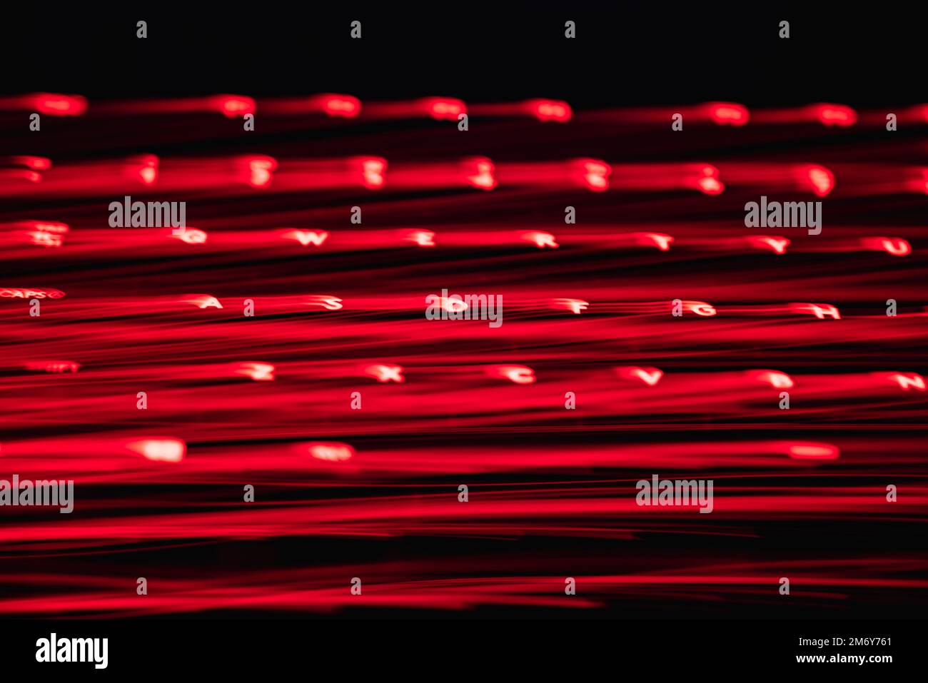 Light painting keyboard letters and numbers. Beautiful colorful background. Long exposure light painting,red color curved lines in vibrant neon. Stock Photo