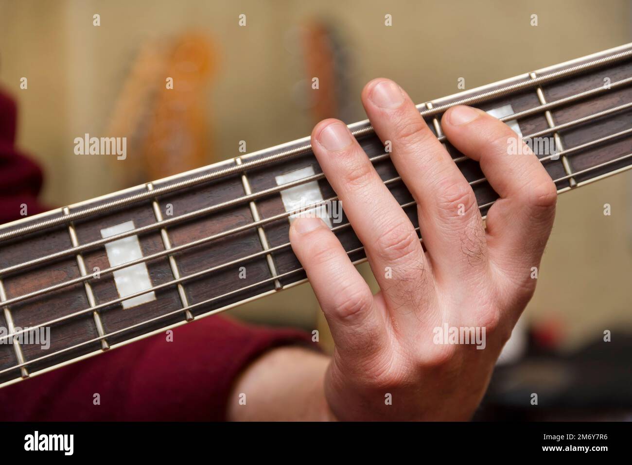Close Up Shot Of Male Hand Playing 5 String Bass Guitar Stock Photo