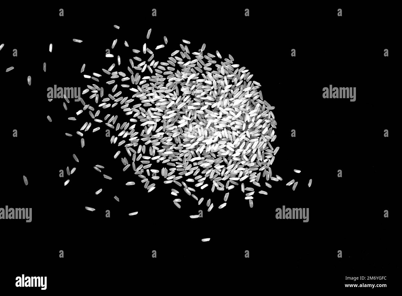 Rice spilled on a black background. Raw white rice explosion isolated