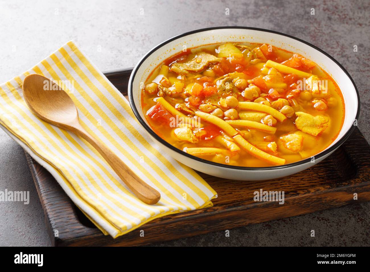 Canarian soup with meat, pasta, chickpeas and vegetables close-up on a plate on the table. horizontal Stock Photo