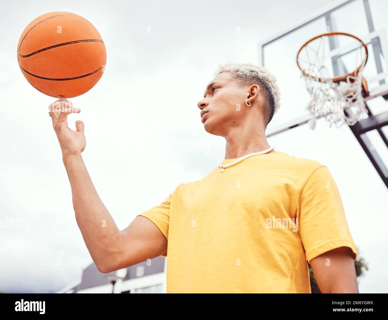 Sports, fitness and man spinning basketball on court outdoors before