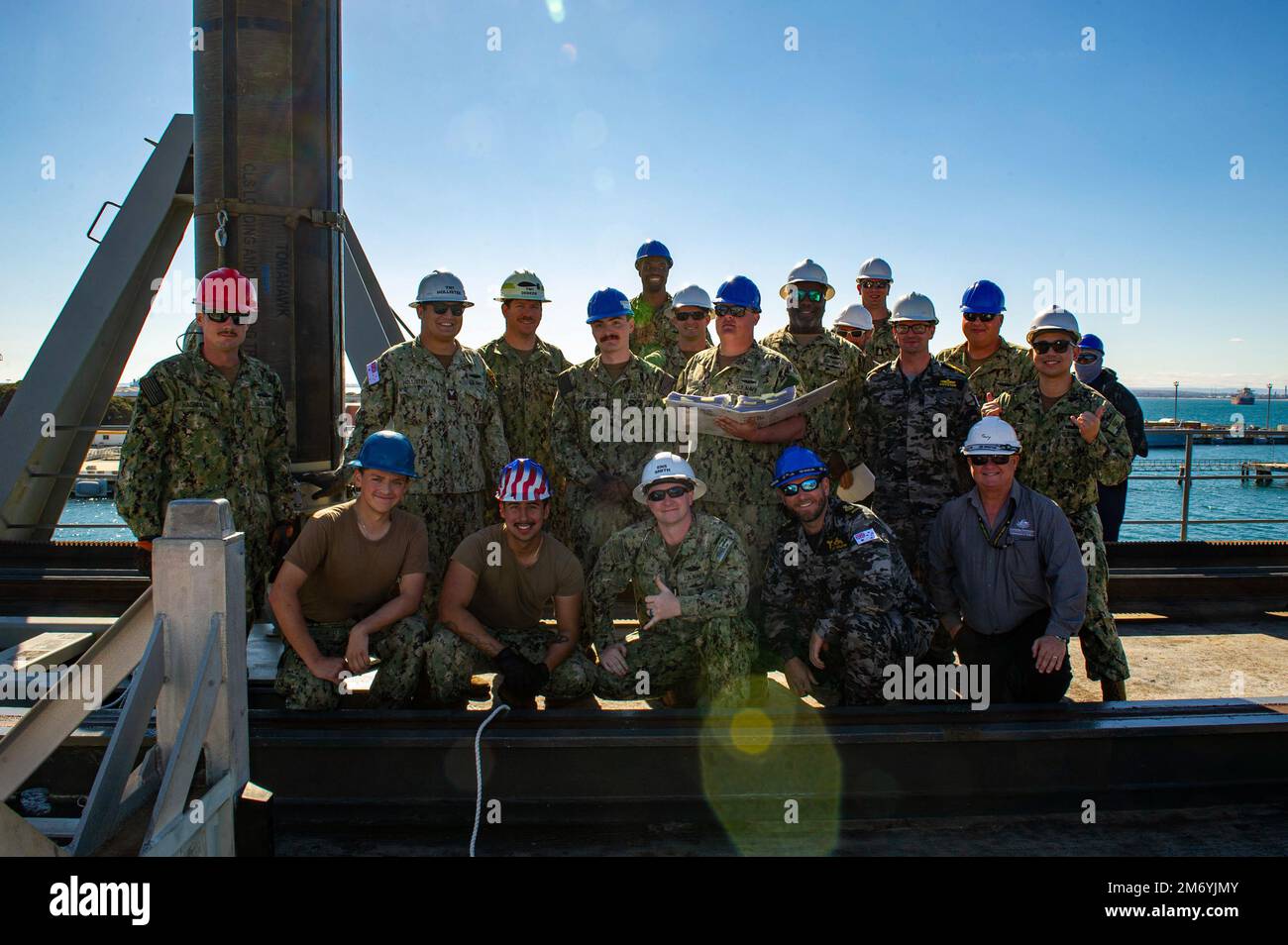 PERTH, Australia (April 20, 2022) – Sailors assigned to the Emory S. Land-class submarine tender USS Frank Cable (AS 40) and Royal Australian Navy sailors, pose for a group photo following a weapons handling training exercise with a Tomahawk training shape aboard the ship at HMAS Stirling Navy Base on Garden Island off the coast of Perth, Australia, April 20, 2022. Frank Cable is currently on patrol conducting expeditionary maintenance and logistics in support of national security in the U.S. 7th Fleet area of operations. Stock Photo