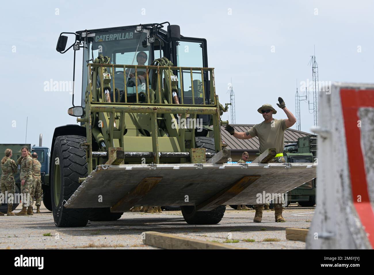 U.S. Air Force Airman 1st Class Ciara Arias, an air transportation specialist with the 156th Contingency Response Group, operates a 10K all-terrain forklift, while Senior Airman Ricardo Aguilera, an air transportation journeyman with the 156th CRG, directs her to move a 463L cargo pallet that will be used to carry equipment on an aircraft during Southern Strike 2022 at Gulfport Combat Readiness Training Center, Gulfport, Mississippi, April 20, 2022. Southern Strike 2022 is a large-scale, joint multinational combat exercise that provides tactical level training for the full spectrum of conflict Stock Photo