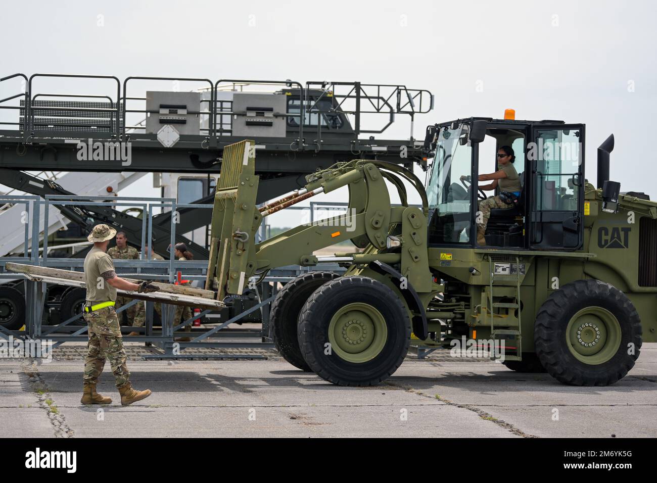 U.S. Air Force Airman 1st Class Ciara Arias, an air transportation journeyman with the 156th Contingency Response Group, operates a 10K all-terrain forklift, while Senior Airman Ricardo Aguilera, an air transportation journeyman with the 156th CRG, directs her to move a 463L cargo pallet that will be used to carry equipment on an aircraft during Southern Strike 2022 at Gulfport Combat Readiness Training Center, Gulfport, Mississippi, April 20, 2022. Southern Strike 2022 is a large-scale, joint multinational combat exercise that provides tactical level training for the full spectrum of conflict Stock Photo