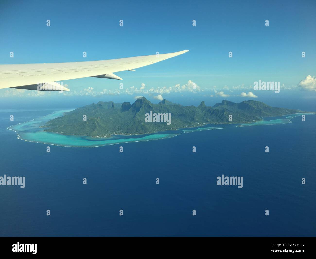 An aerial view of Mo'orea, French Polynesia with an airplane wing visible above it Stock Photo
