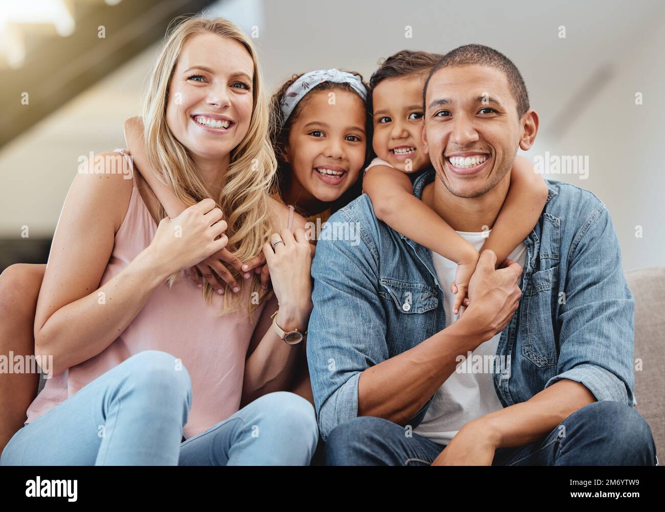 Kids, interracial and family on sofa for portrait, happy family and home together in Chicago, USA. Care, hug and smile of children embracing, happy Stock Photo