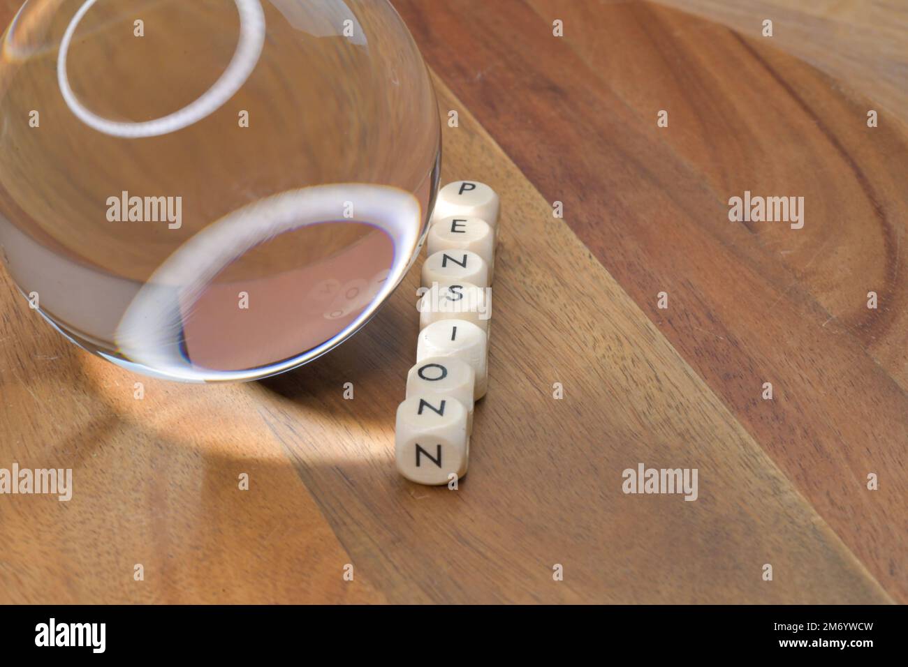 A crystal ball next to a row of block letters spelling out the word pension, future of pension, financing retirees, future prediction of pension value Stock Photo