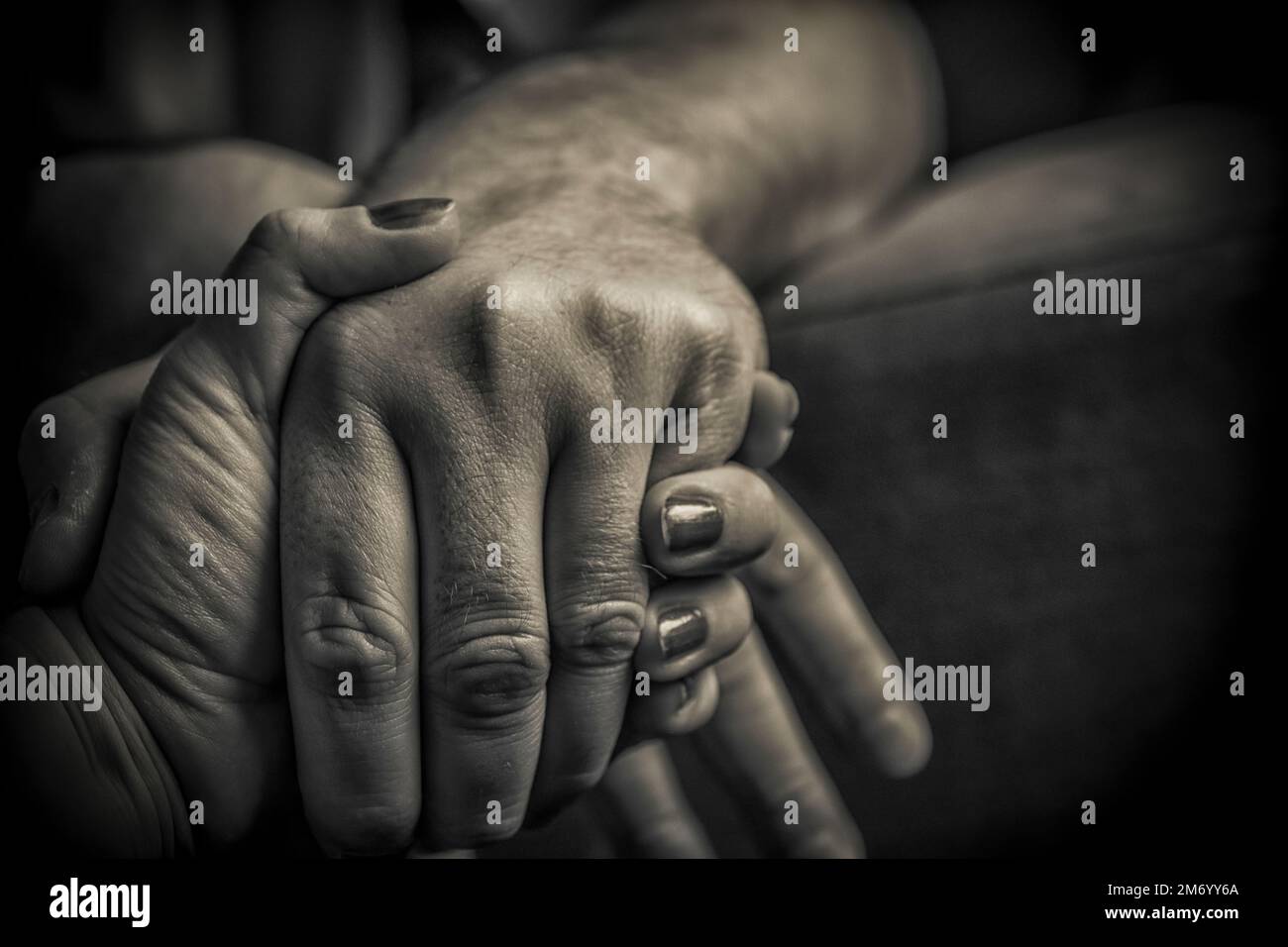 A close-up of man and woman holding hands in black and white Stock ...