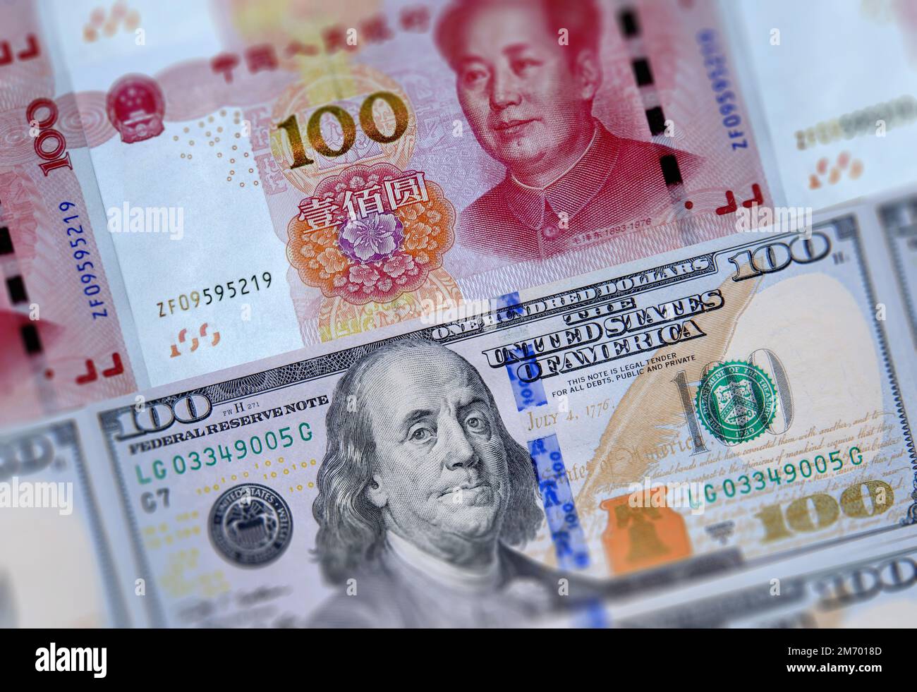 US 100 dollars bills and Chinese currency yuan banknotes closeup background. USA China business