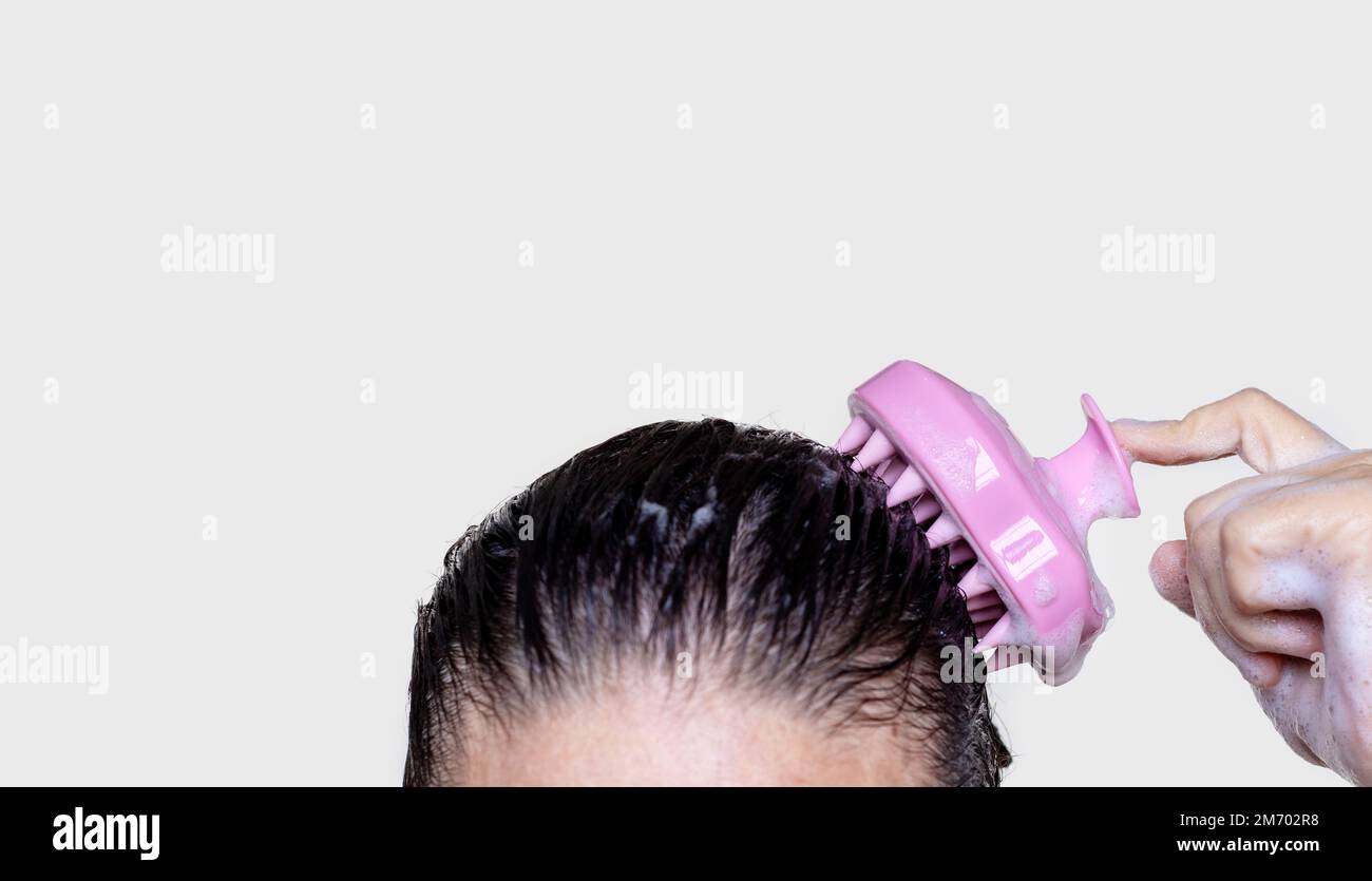 hair growth stimulating,scalp massage.woman use massager shampoo brush