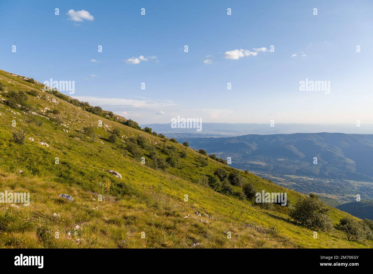 Slopes around the mountain with low grass and karst rocks Stock Photo
