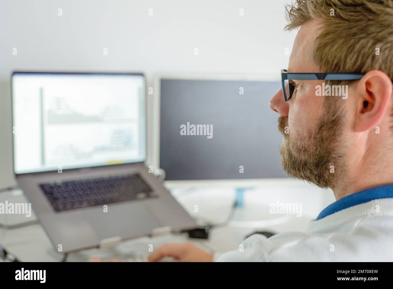 Computer programmer writing program code on computer in office Stock Photo