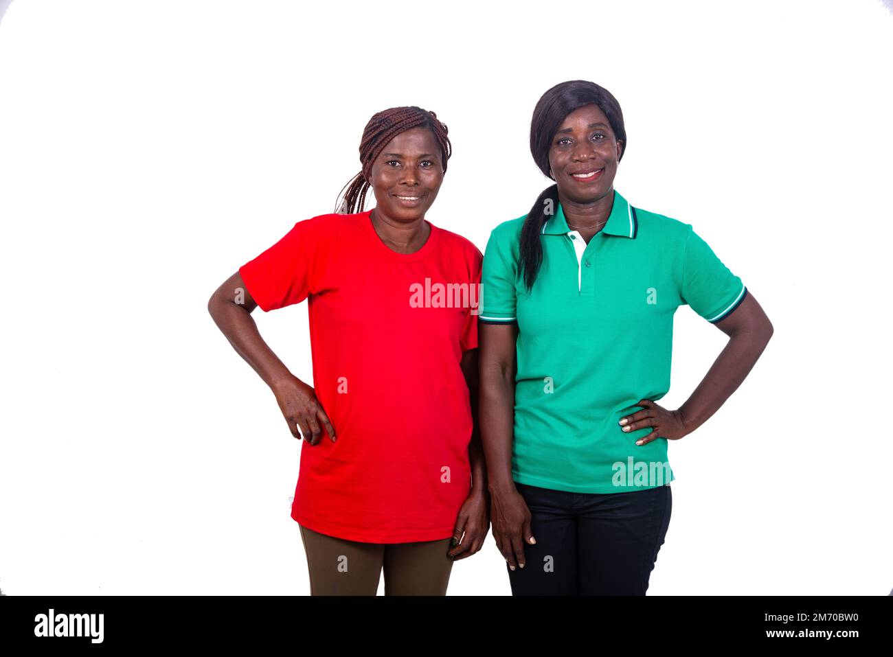 portrait of two beautiful mature women holding hands on hip while smiling at camera. Stock Photo