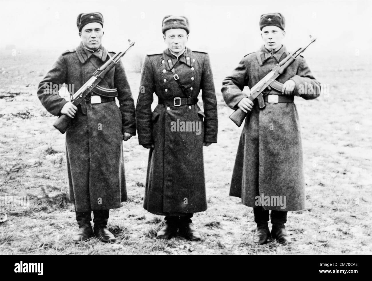 USSR - circa 1955: two ordinary soldiers with Kalashnikov assault rifles and their commander Stock Photo