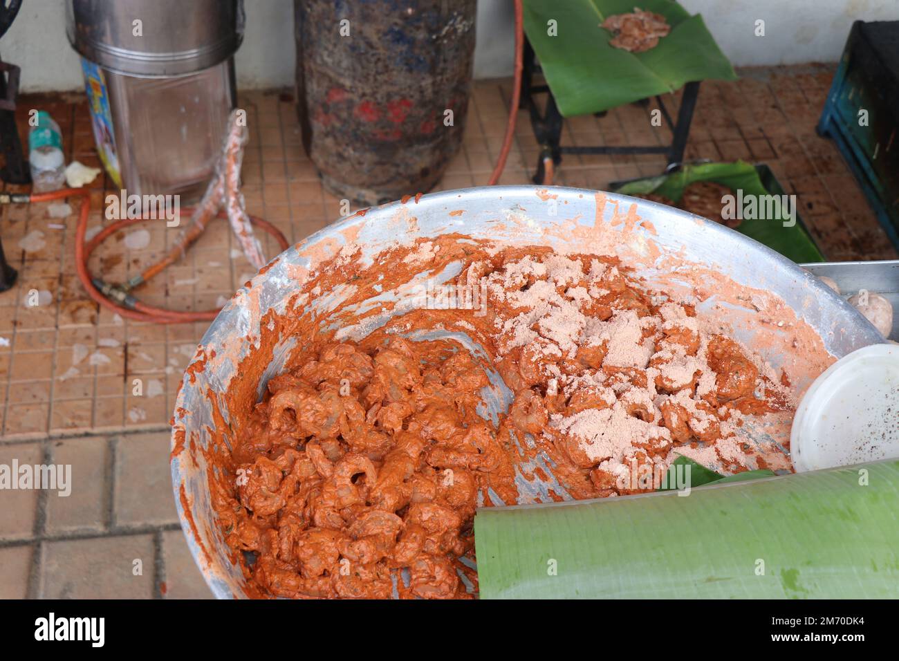 Vessel full of marinated prawns mixed with spices and other ingredients ready to be fried in deep oil Stock Photo