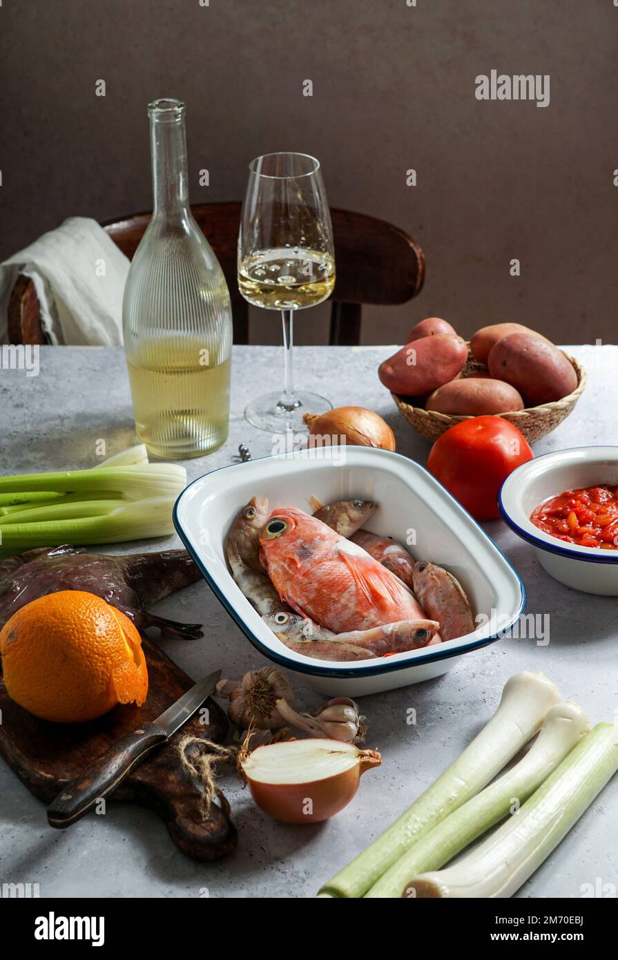 ingredients for french soup Bouillabaisse with devil fish, Sebastes, with tomatoes and white wine, top view Stock Photo