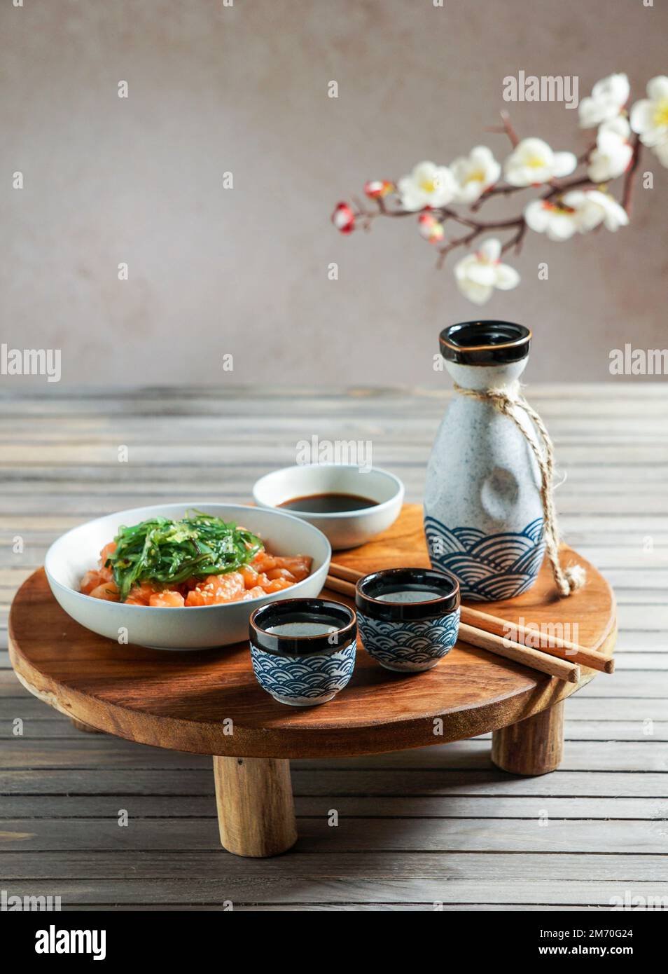 Japanese sake and salmon sashimi and wakame seaweed on asian wood table ...