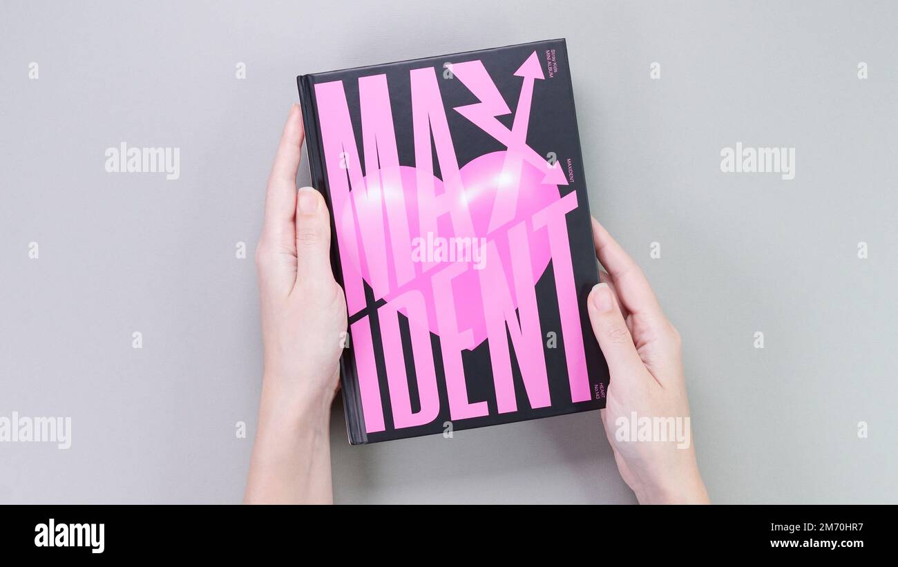 Hands holding Stray Kids MAXIDENT mini Album Box set on grey. Pink music CD. South Korean boy band StrayKids. Space for text. Gatineau, QC Canada - De Stock Photo