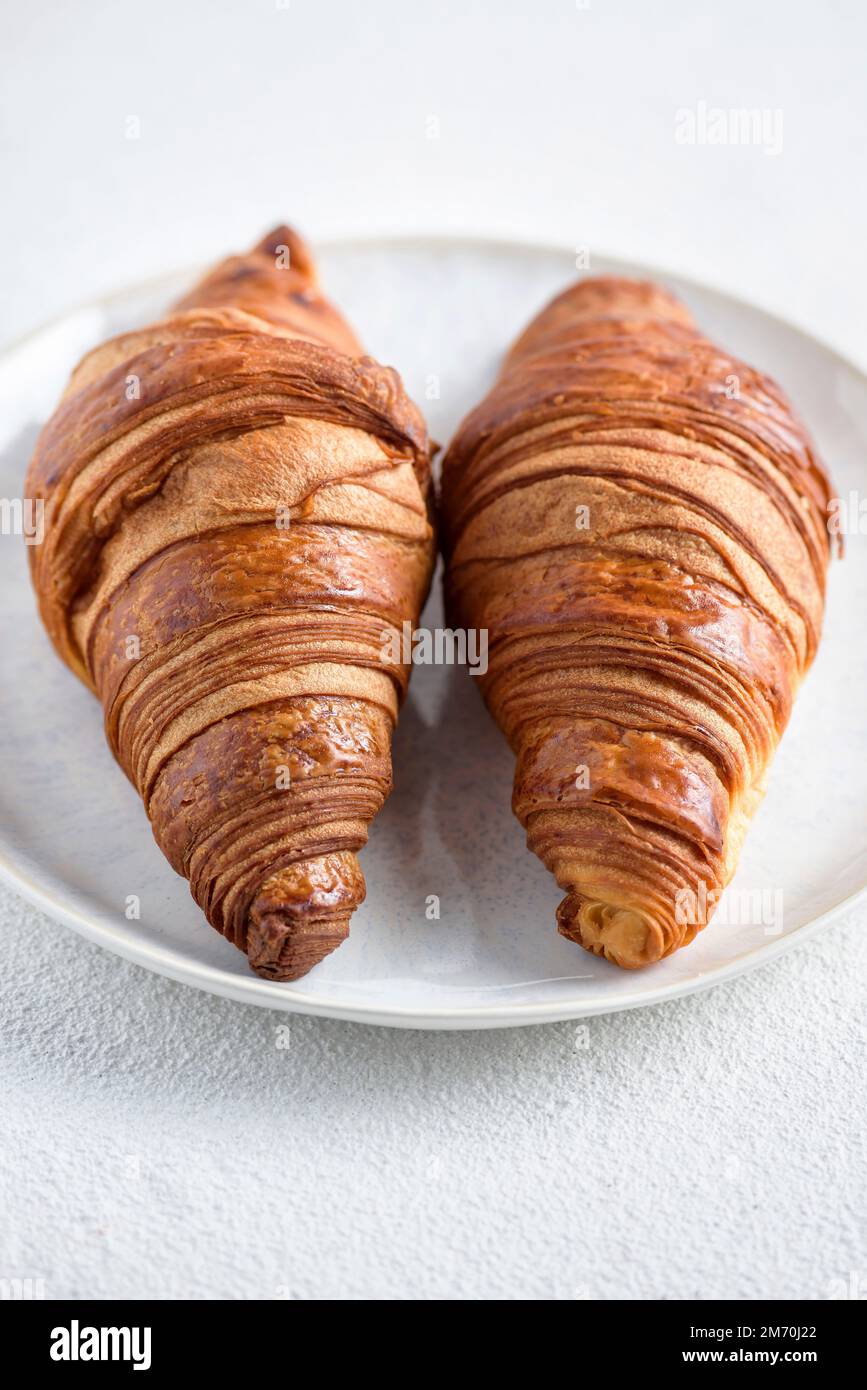 Two croissants on a white plate. Stock Photo