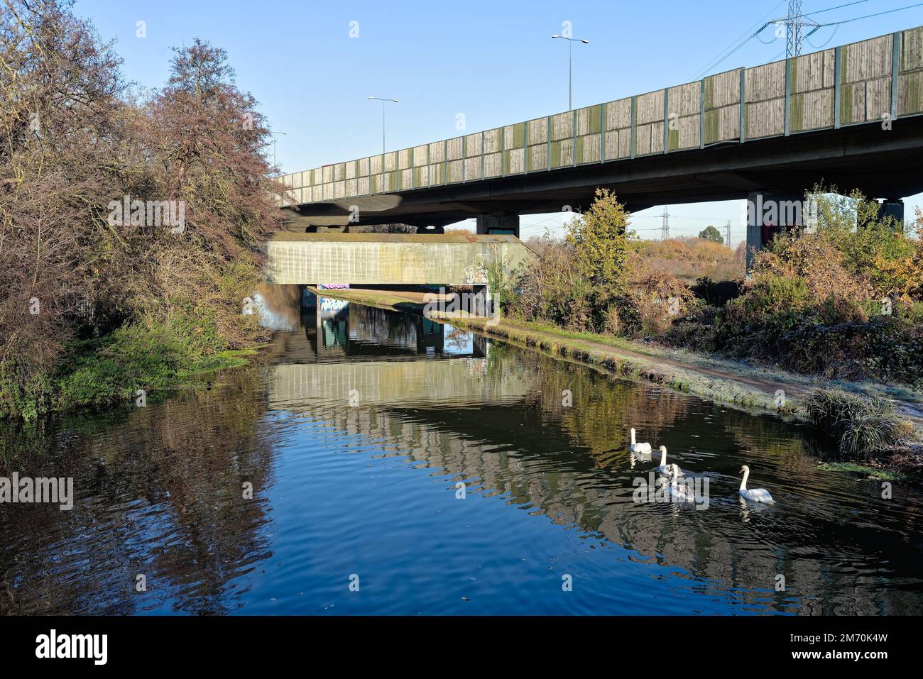 Brutalist industrial structures passing over the River Wey navigation canal ,on a sunny winters day, New Haw Surrey England UK Stock Photo