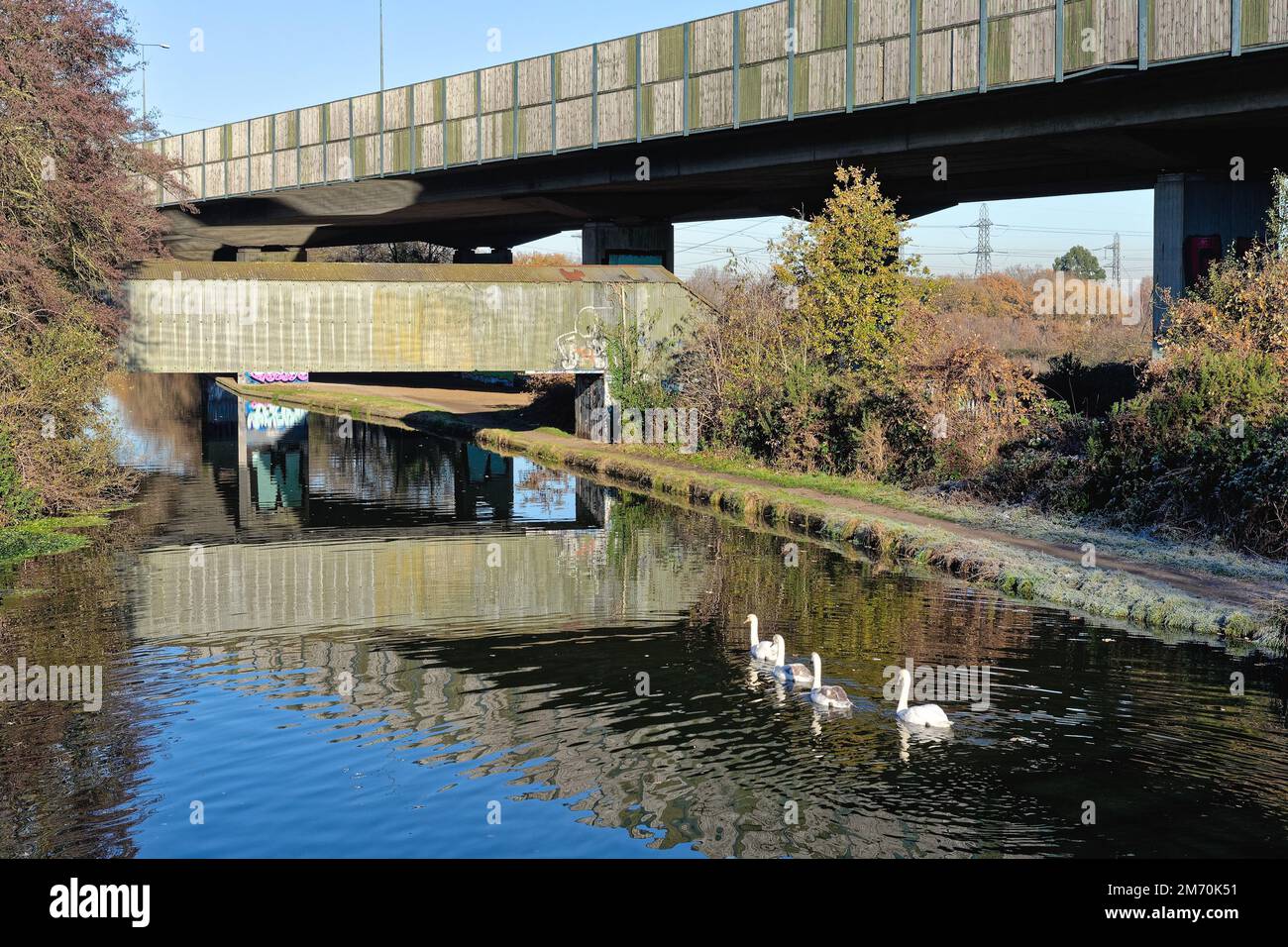 Brutalist industrial structures passing over the River Wey navigation canal ,on a sunny winters day, New Haw Surrey England UK Stock Photo