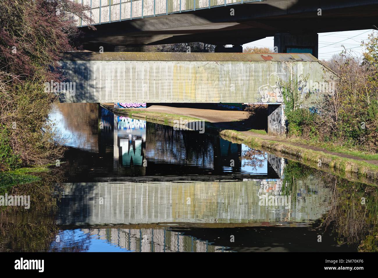 Brutalist industrial structures passing over the River Wey navigation canal ,on a sunny winters day, New Haw Surrey England UK Stock Photo
