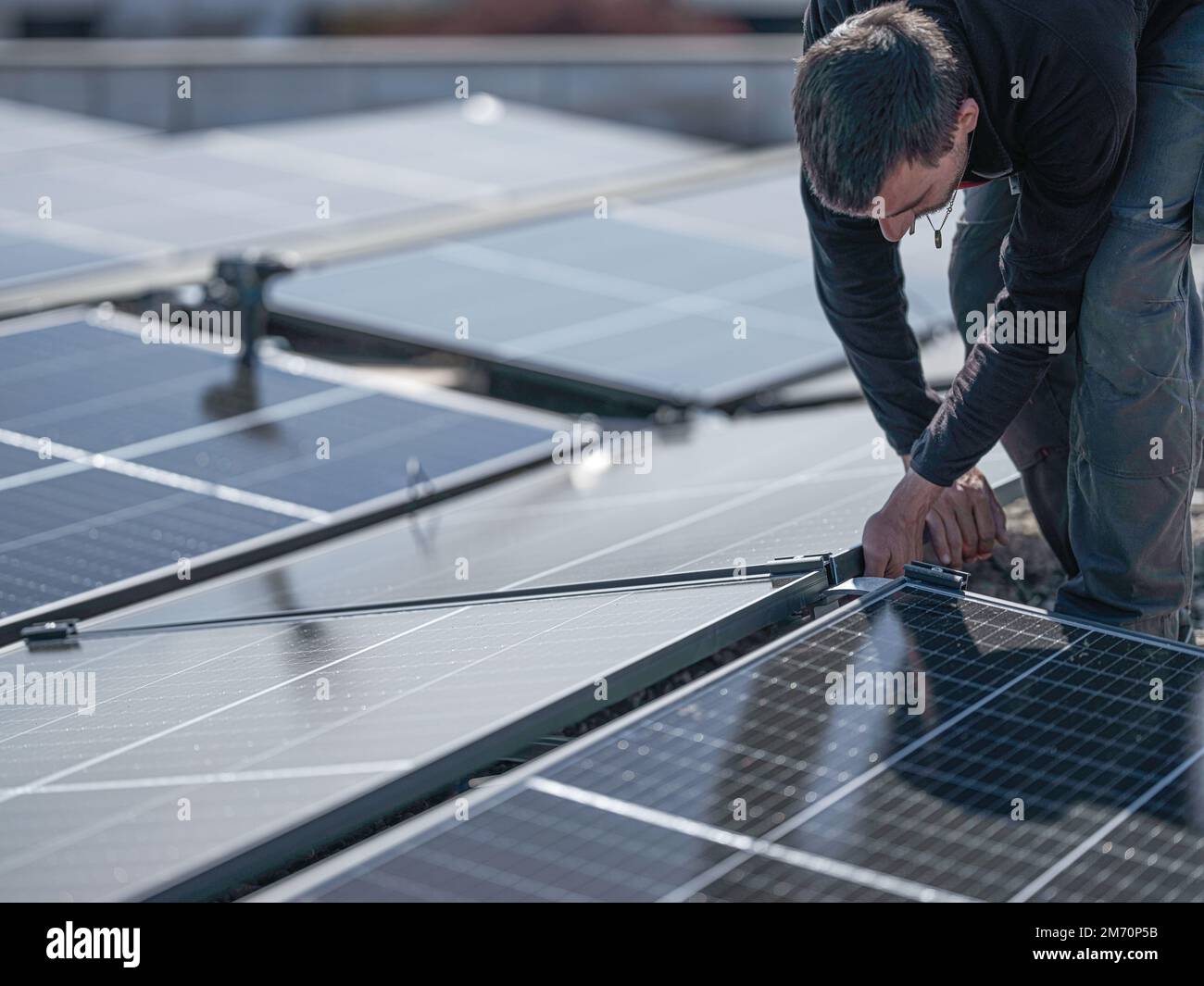 Male team engineers installing stand-alone solar photovoltaic panel ...