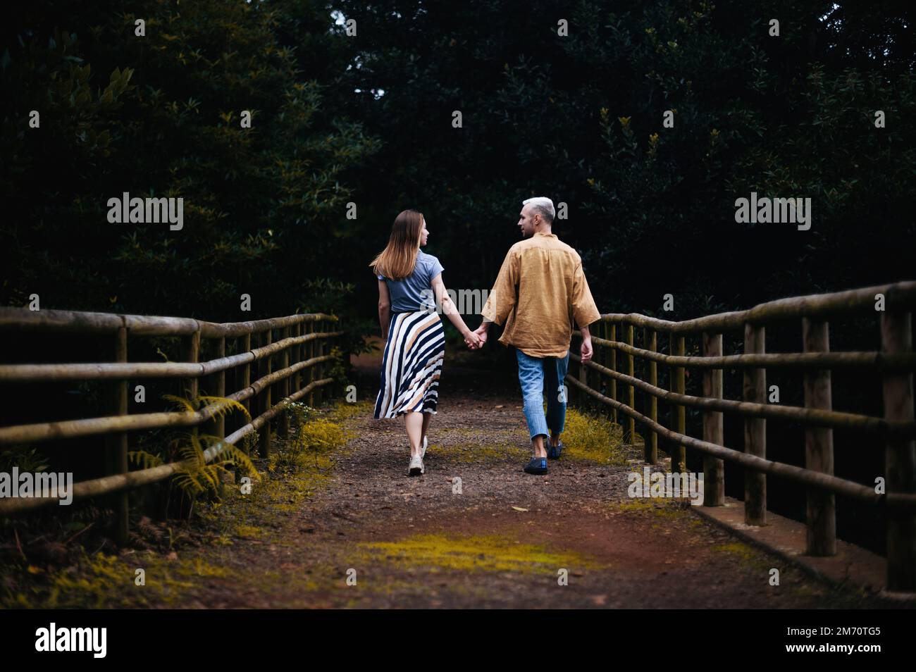 A romantic photo of a young couple in a beautiful autumn park, walking ...