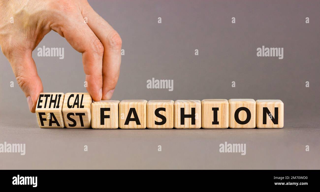 Fast or ethical fashion symbol. Concept words Fast fashion and Ethical fashion on wooden cubes. Businessman hand. Beautiful grey background. Business Stock Photo