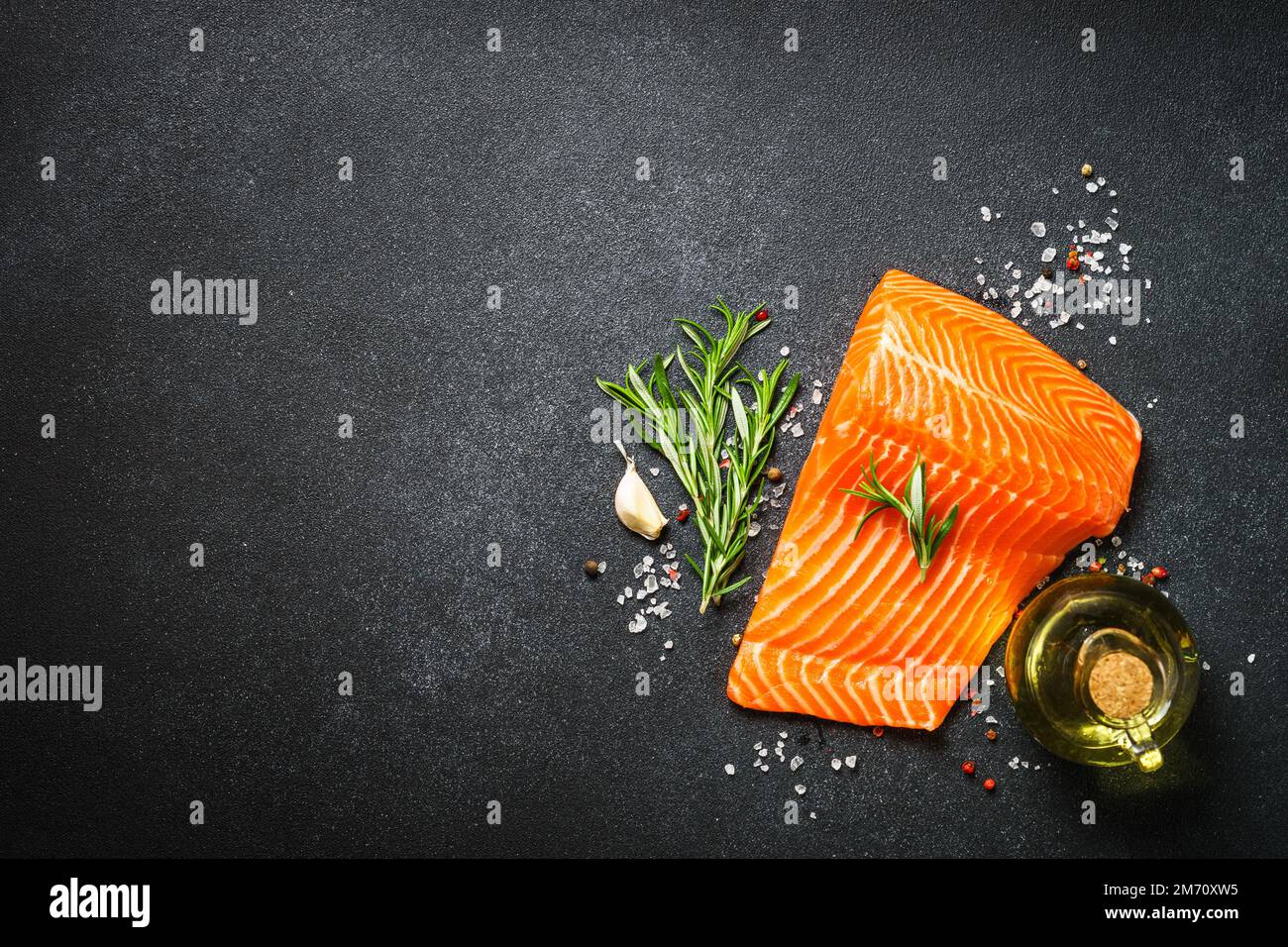Raw salmon, fresh fish fillet at black background Stock Photo - Alamy