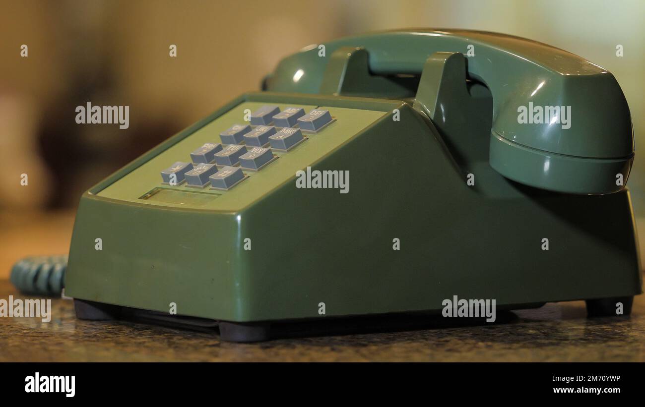 Retro push button rotary dial telephone. Vintage avocado green landline