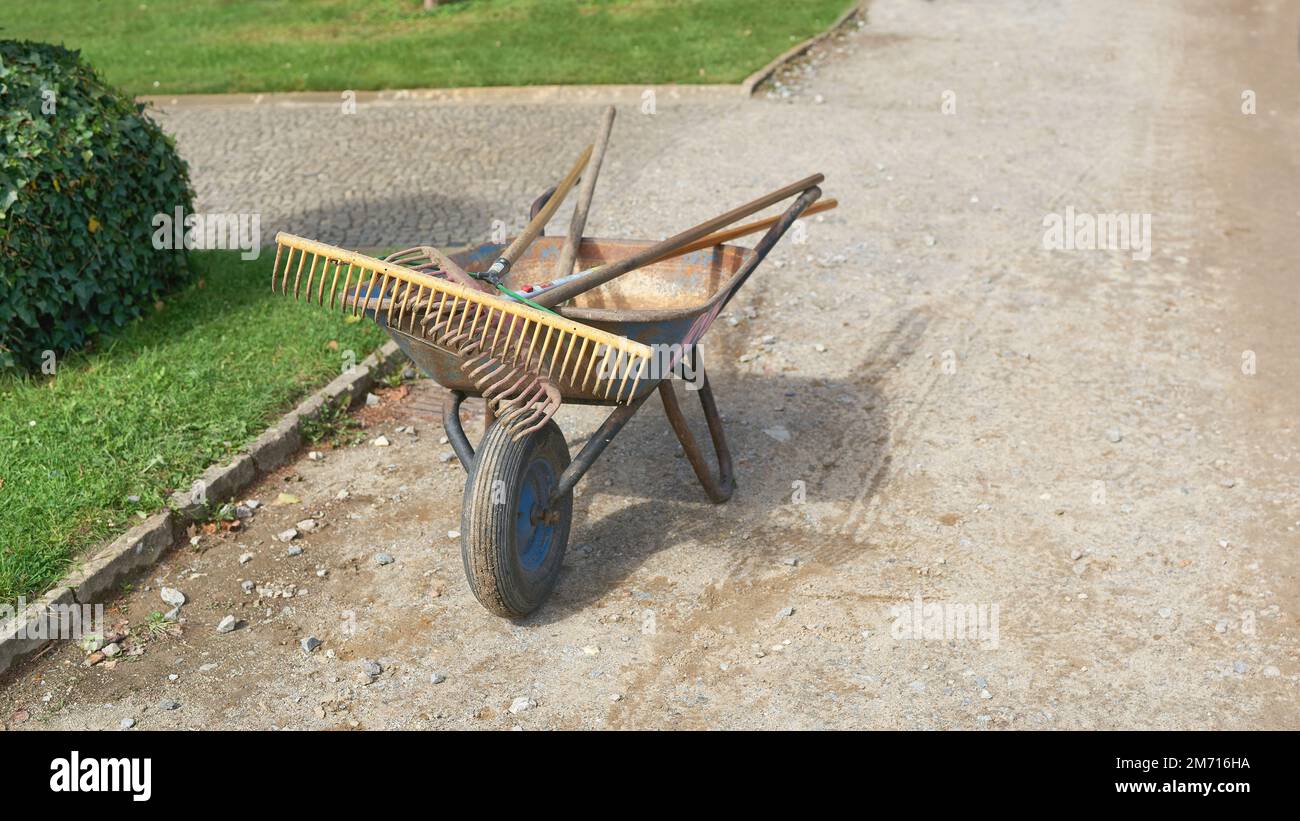 Wheelbarrow with rake in public park in Germany after work done Stock