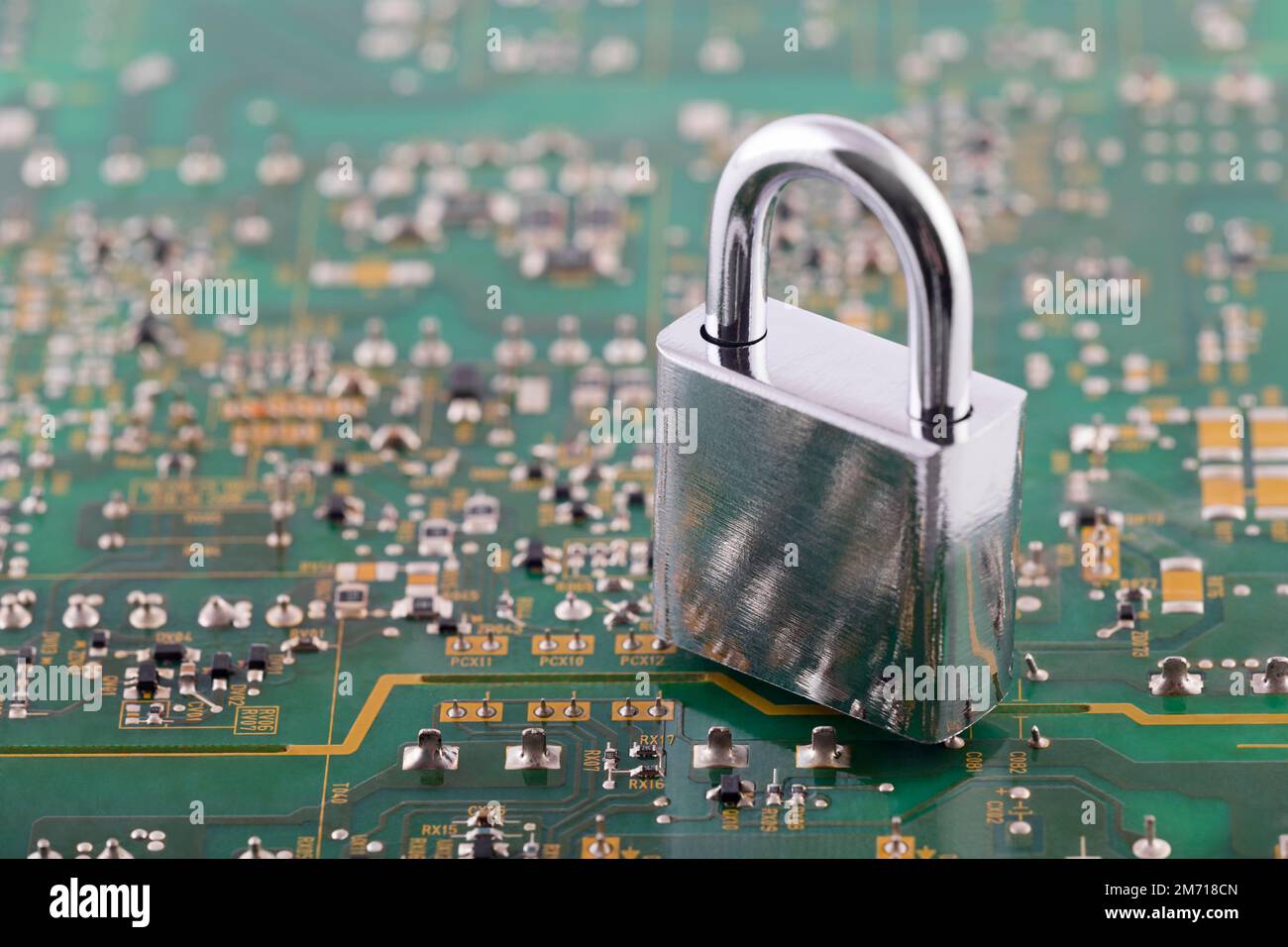 Computer security concept. Silver padlock on green computer circuit board Stock Photo