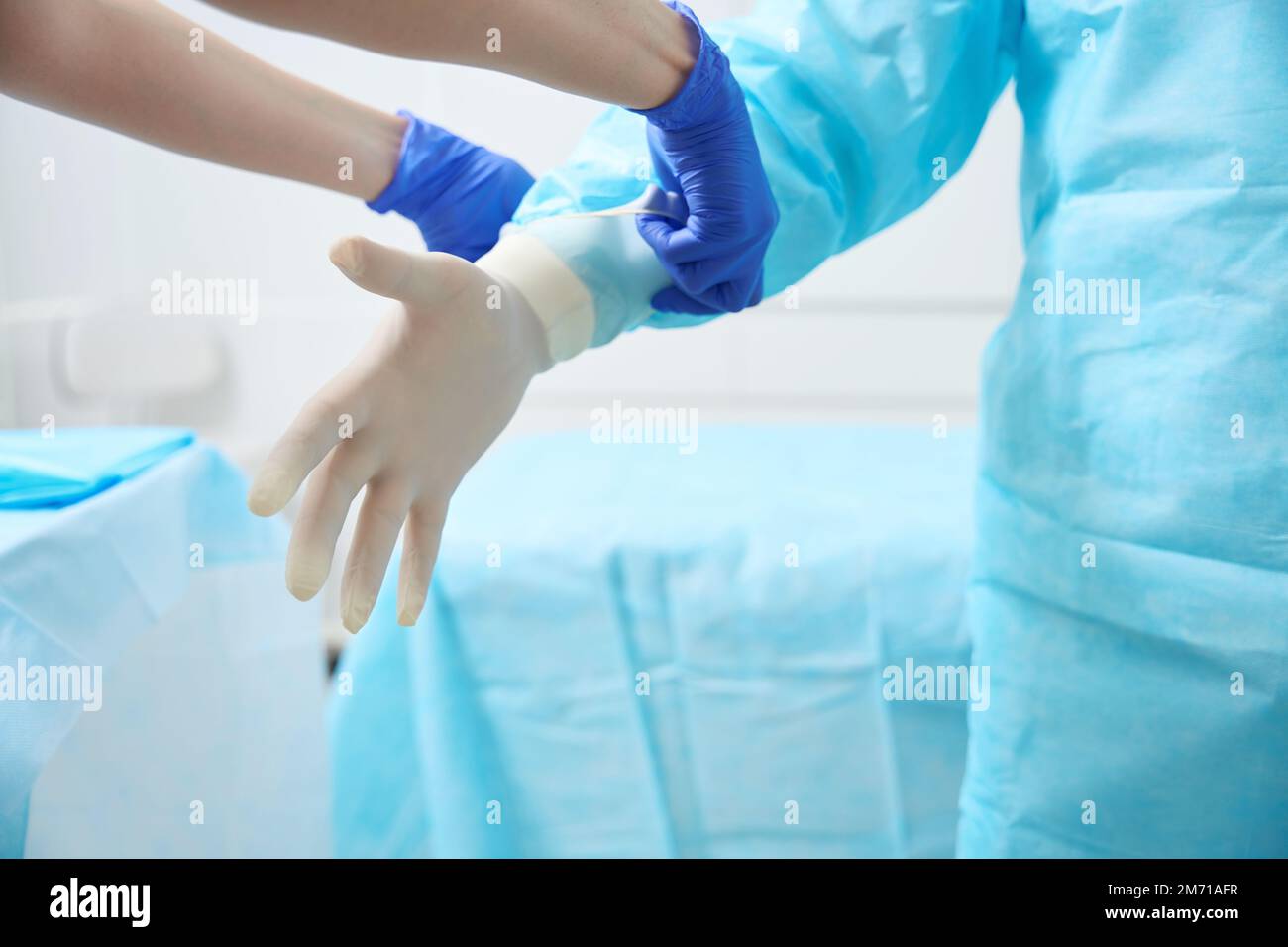 Nurse helps the doctor put on overalls before the operation Stock Photo ...