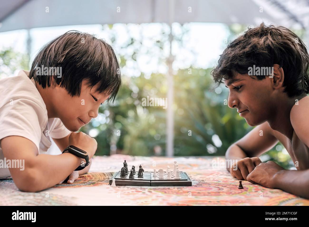 A Boy Of Indian Origin Stares At The Camera While Playing Chess Front