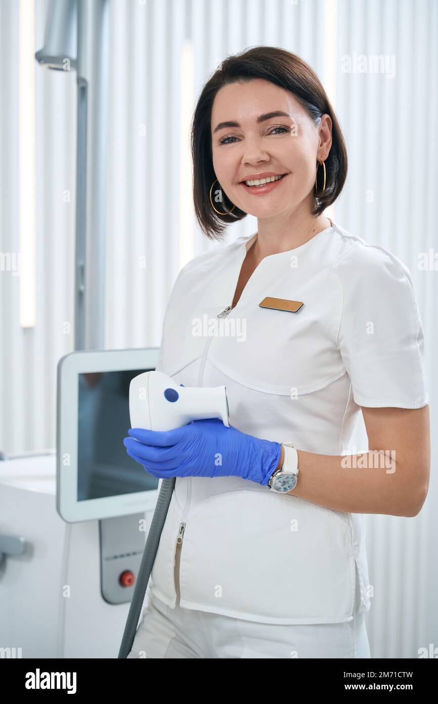 Woman physiotherapist holds an applicator of shock wave therapy apparatus Stock Photo Alamy
