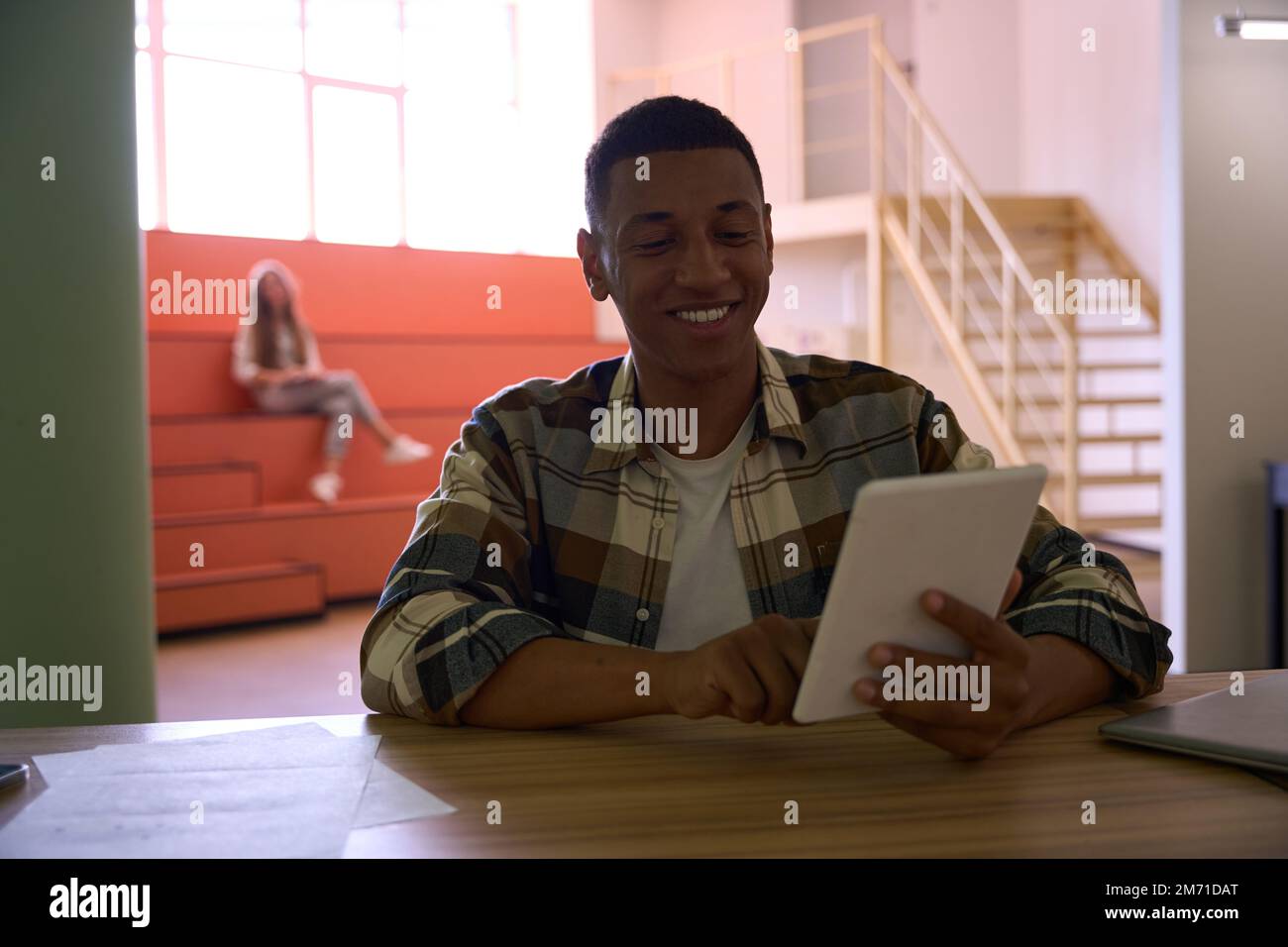 Happy African American guy is using tablet Stock Photo