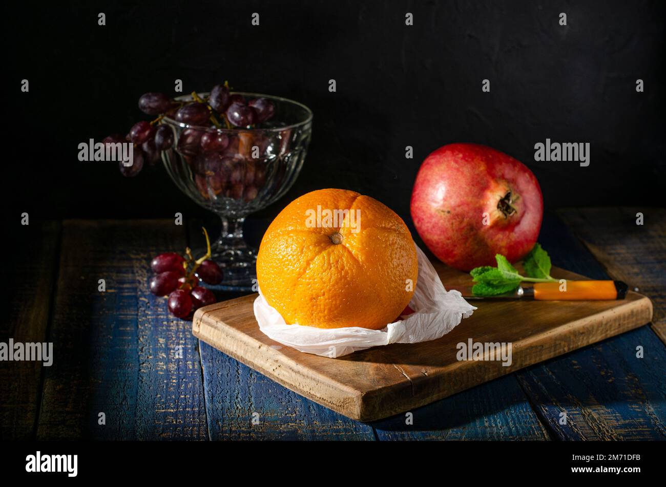 Still life with orange pomegranate and grapes in still of a Dutch ...