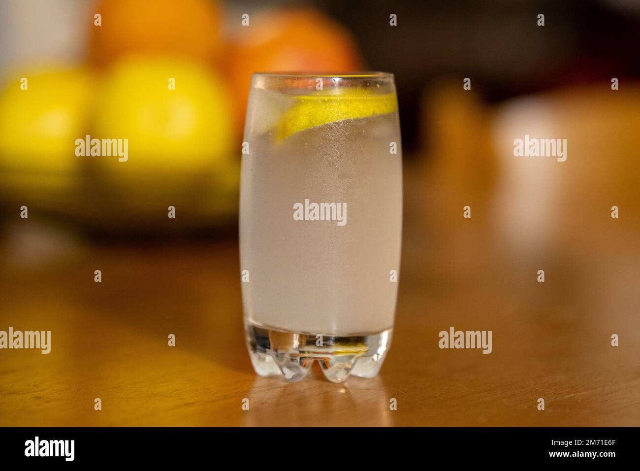 Glass cup with sparkling water and lemon. wooden background, Citrus