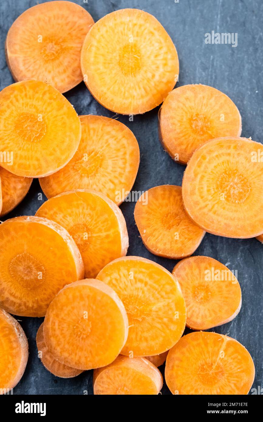 Sliced orange carrots macro on a slate background. Stock Photo