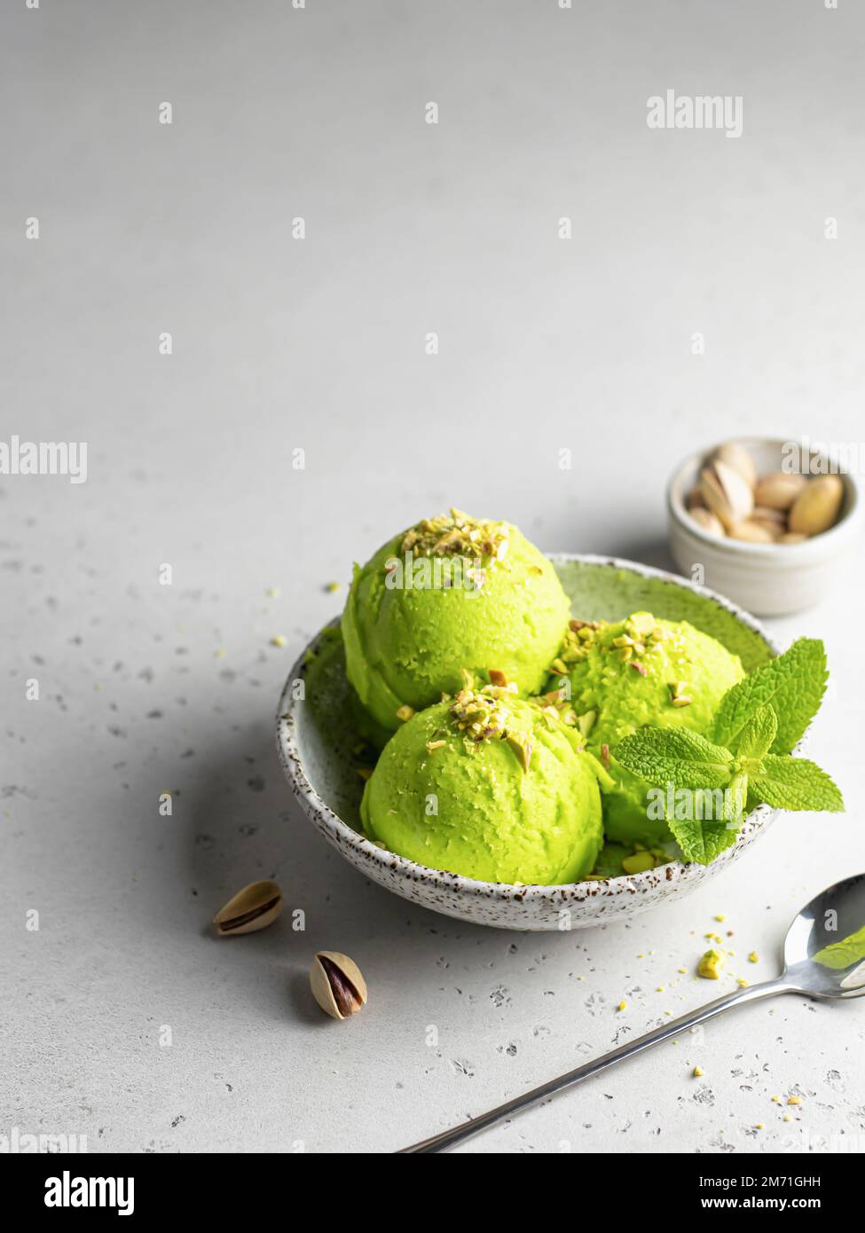 Pistachio ice cream scoop garnished with chopped pistachios and mint ...